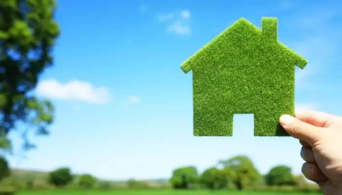 hand holding green home outside hand holding green home outside